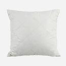 White pillow with a diamond pattern on a light gray background